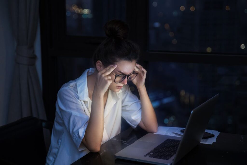 Overtime concept. Woman is working with laptop at home during night.