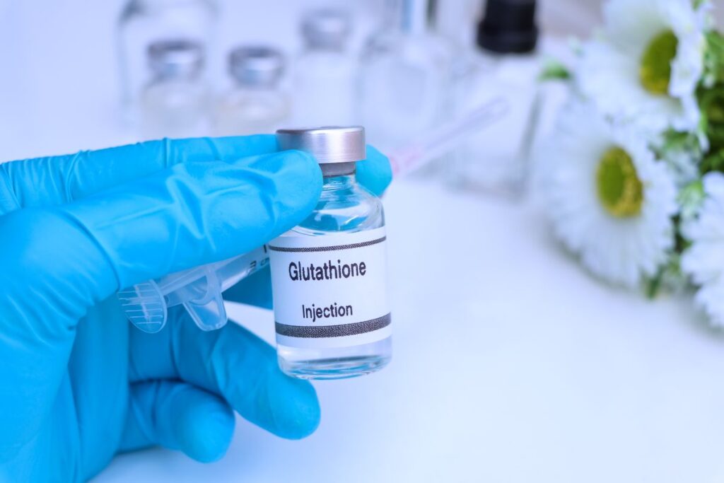 bottle of glutathione held by a person holding blue gloves