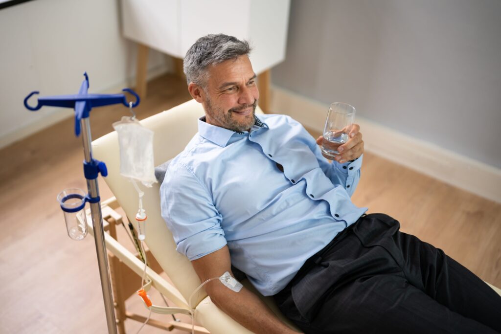 Old man receiving NAD IV infusion inside an office